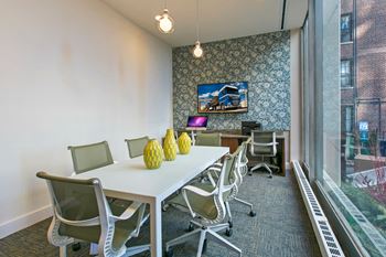 a conference room with a white table and chairs and a large window